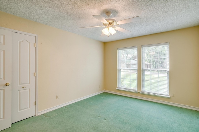 carpeted empty room with a textured ceiling and ceiling fan