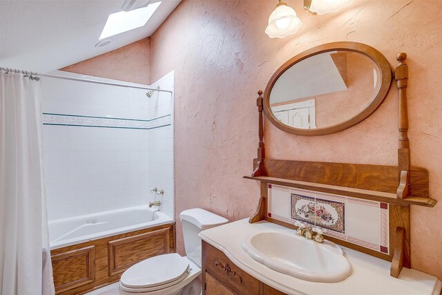 full bathroom with vanity, a skylight, shower / bath combo with shower curtain, and toilet