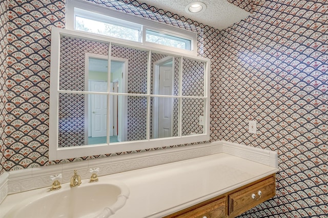 bathroom with a textured ceiling and vanity