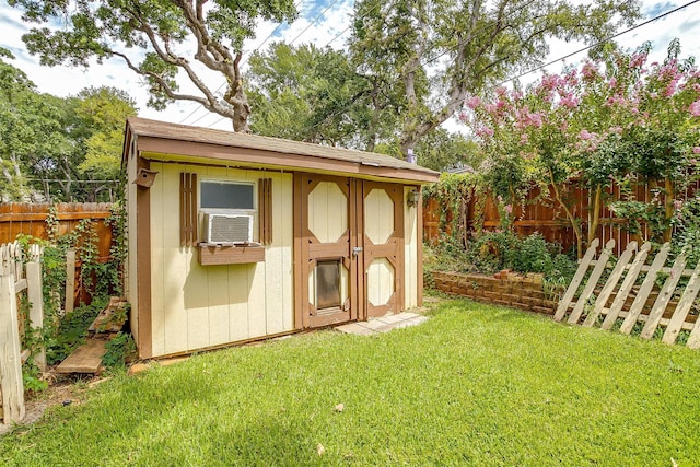 view of outdoor structure featuring cooling unit and a lawn