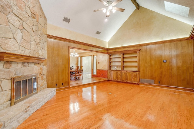 unfurnished living room with wood walls, beamed ceiling, hardwood / wood-style flooring, and a fireplace