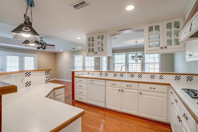 kitchen with pendant lighting, white cabinets, white appliances, and a healthy amount of sunlight