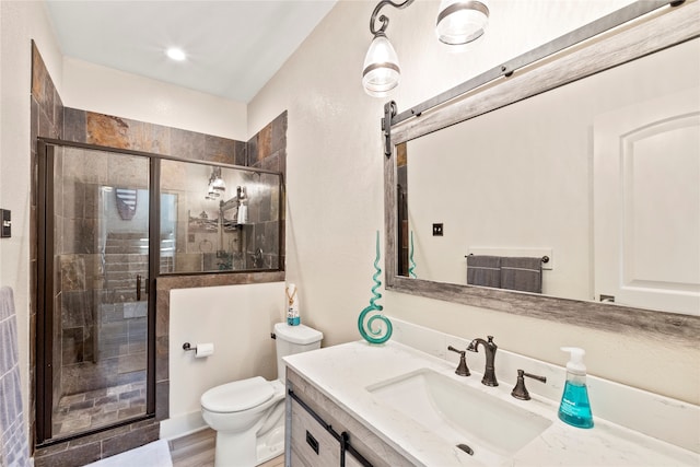 bathroom featuring an enclosed shower, toilet, and vanity