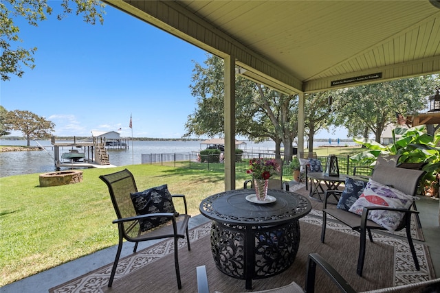 view of patio / terrace featuring a water view, a boat dock, and a fire pit