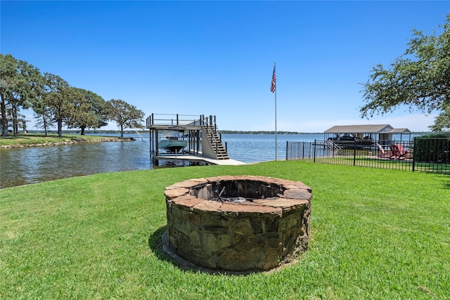 dock area featuring a fire pit, a lawn, and a water view