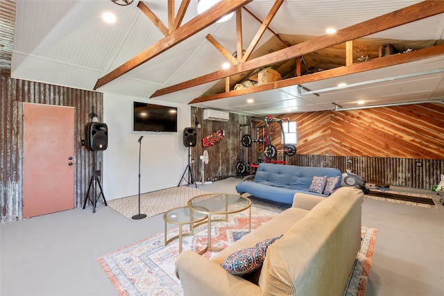 living room with vaulted ceiling, wood walls, a wall unit AC, and concrete floors