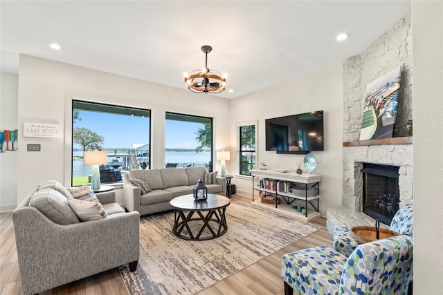 living room featuring light hardwood / wood-style floors, a chandelier, and a fireplace