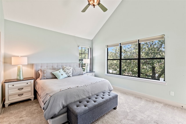 carpeted bedroom with ceiling fan and high vaulted ceiling