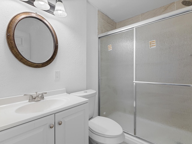 bathroom featuring walk in shower, vanity, and toilet