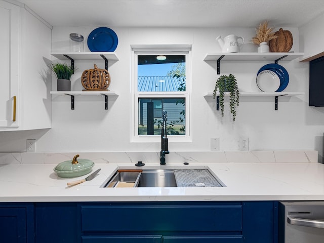 kitchen featuring blue cabinetry, light stone counters, sink, and plenty of natural light