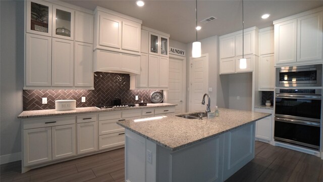 168 Falcon Point Dr, Heath, TX 75032 - kitchen featuring white cabinets, an island with sink, light stone countertops, dark wood-type flooring, and sink