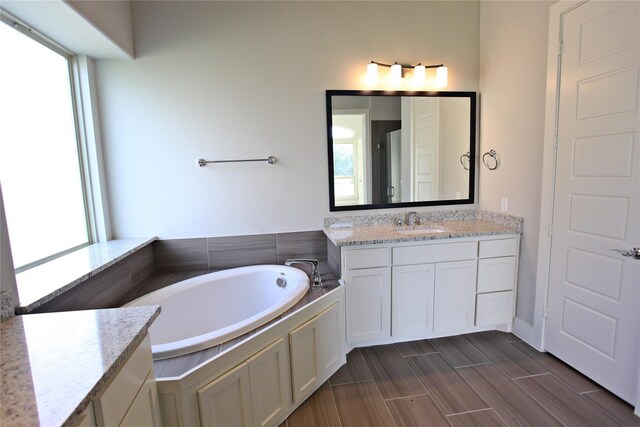 168 Falcon Point Dr, Heath, TX 75032 - bathroom featuring a wealth of natural light, vanity, hardwood / wood-style floors, and a tub