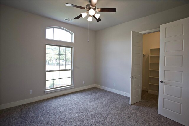 168 Falcon Point Dr, Heath, TX 75032 - unfurnished bedroom featuring a spacious closet, ceiling fan, and carpet flooring