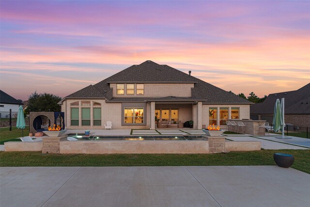 168 Falcon Point Dr, Heath, TX 75032 - back house at dusk featuring a patio, a hot tub, and an outdoor fire pit
