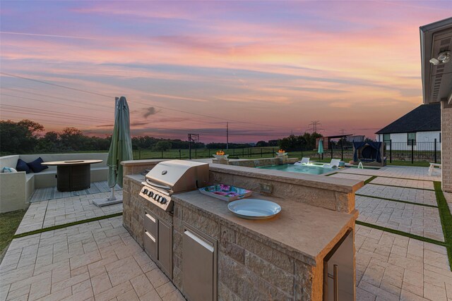 168 Falcon Point Dr, Heath, TX 75032 - patio terrace at dusk with grilling area and an outdoor kitchen