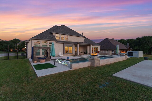 168 Falcon Point Dr, Heath, TX 75032 - back house at dusk featuring a patio area, a pool with hot tub, and a lawn