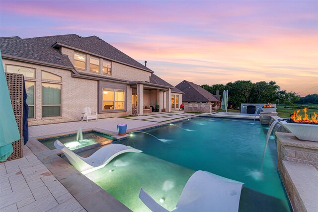 168 Falcon Point Dr, Heath, TX 75032 - pool at dusk featuring an in ground hot tub, pool water feature, and a patio area
