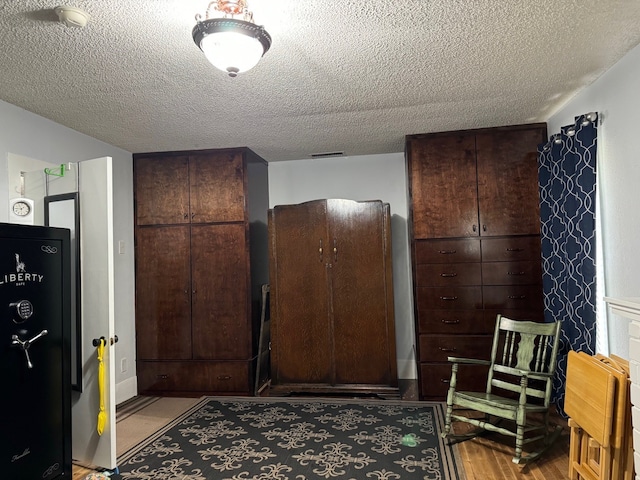 interior space featuring light wood-type flooring and a textured ceiling