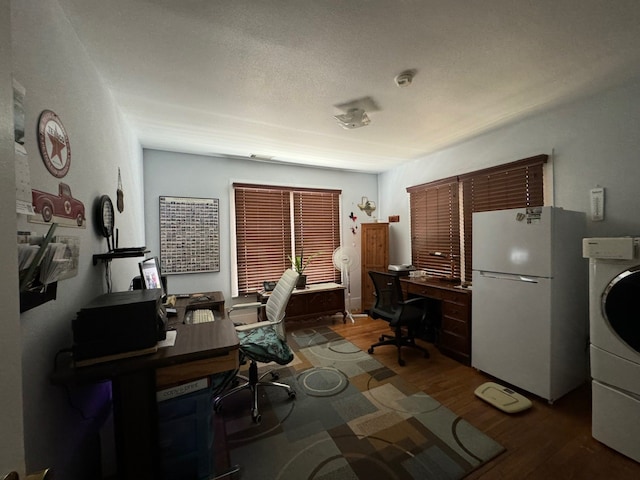 home office with hardwood / wood-style floors, washer / dryer, and a textured ceiling