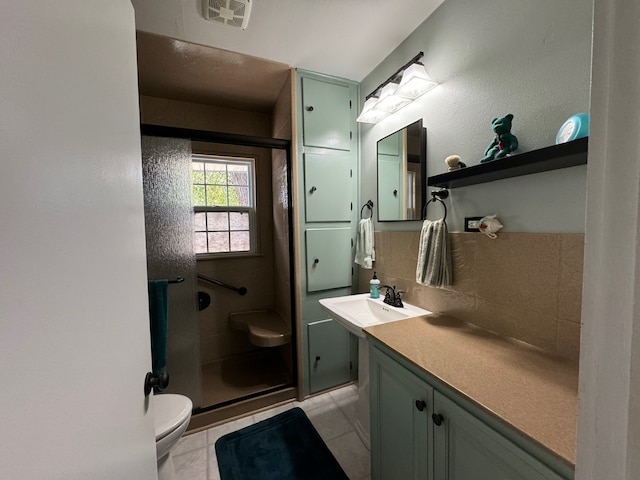 bathroom featuring vanity, tasteful backsplash, tile patterned floors, toilet, and a shower with door