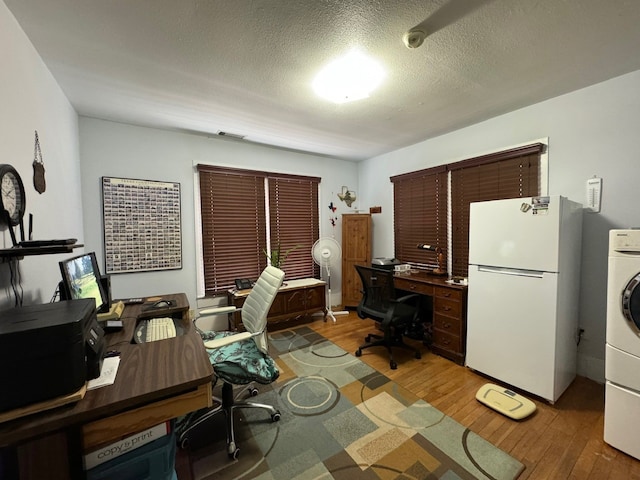 office featuring hardwood / wood-style floors, washer / dryer, and a textured ceiling