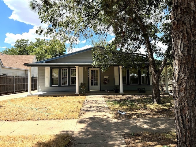 view of front of home with a porch and fence