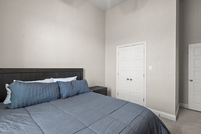 bedroom featuring carpet flooring, a closet, and a towering ceiling