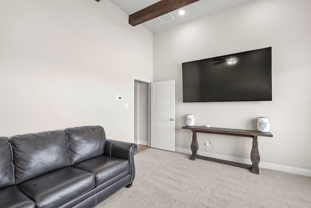 carpeted living room featuring beam ceiling and high vaulted ceiling