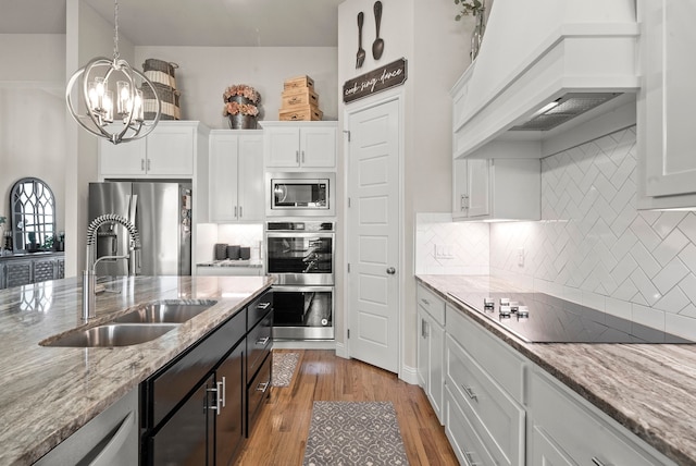 kitchen featuring backsplash, appliances with stainless steel finishes, white cabinetry, sink, and custom exhaust hood