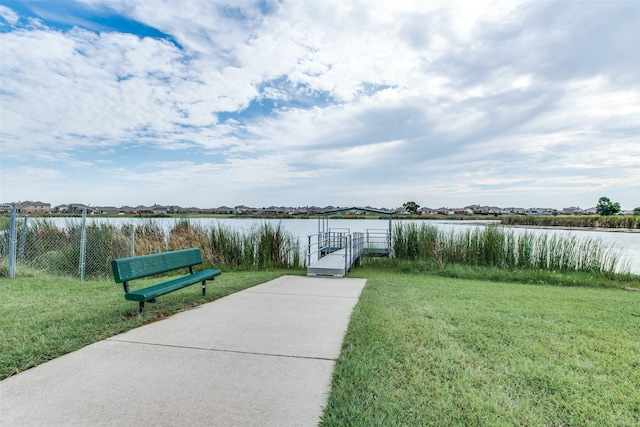 view of dock with a water view and a yard