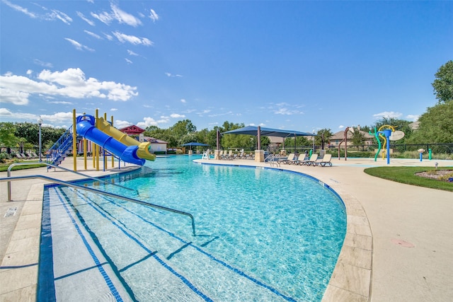 view of swimming pool with a playground and a water slide