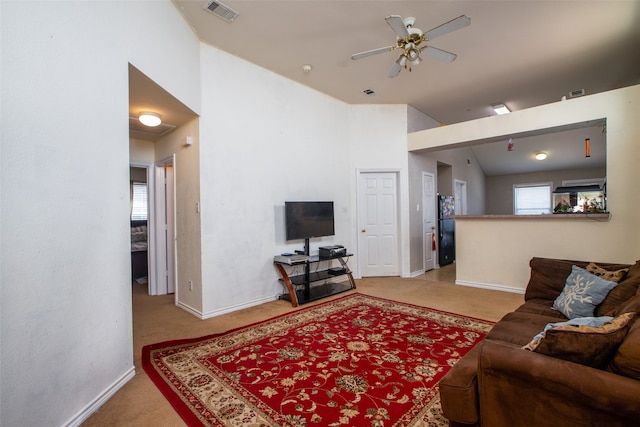 carpeted living room featuring ceiling fan and vaulted ceiling