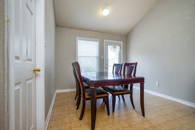 dining area featuring lofted ceiling and light tile patterned floors