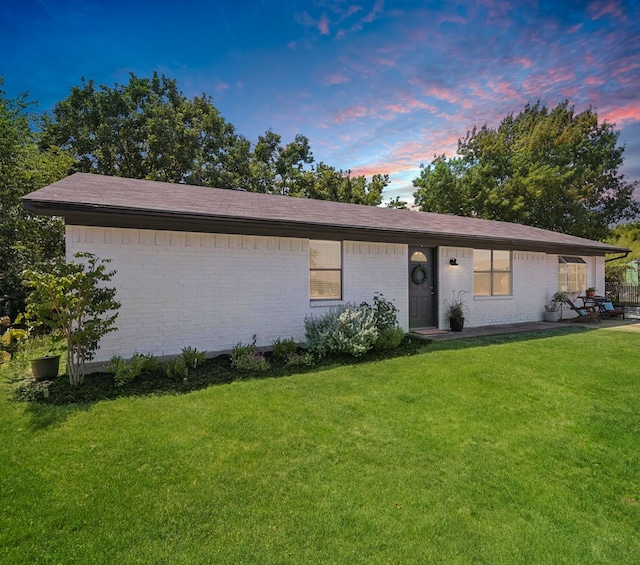 ranch-style home with a yard