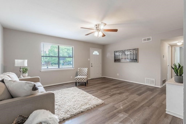 living room with ceiling fan and dark wood-type flooring