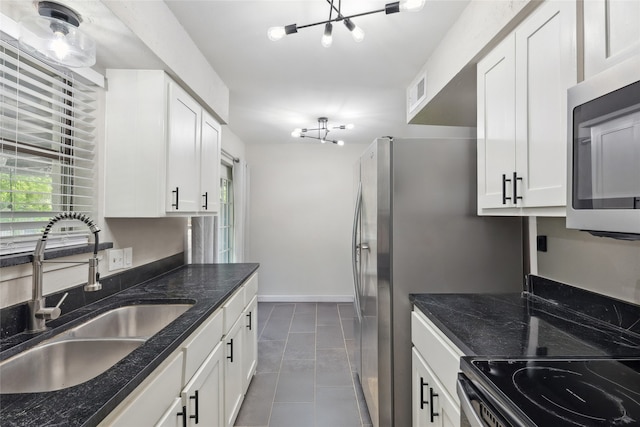 kitchen with white cabinetry, dark tile patterned floors, and sink