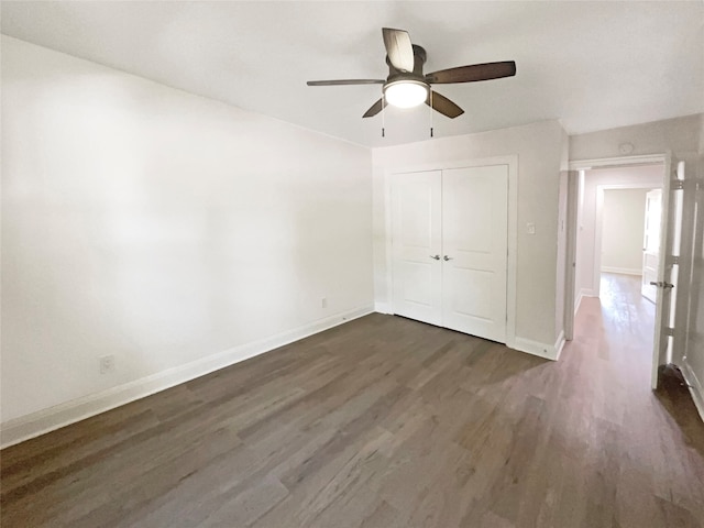 unfurnished bedroom featuring a closet, ceiling fan, and dark hardwood / wood-style flooring