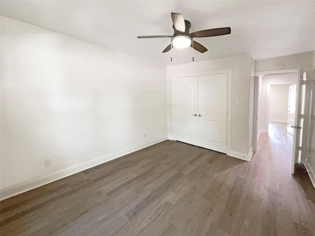 unfurnished bedroom with ceiling fan, dark wood-type flooring, and a closet