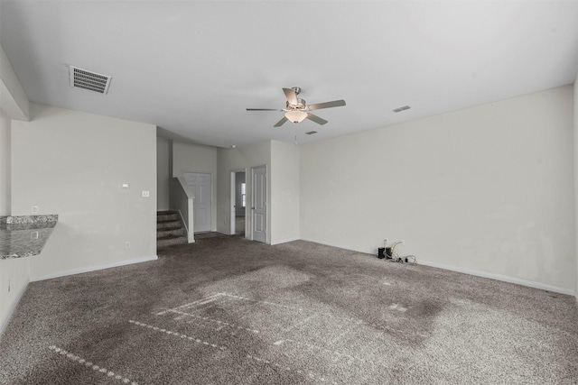 unfurnished living room with carpet flooring, visible vents, a ceiling fan, and stairs