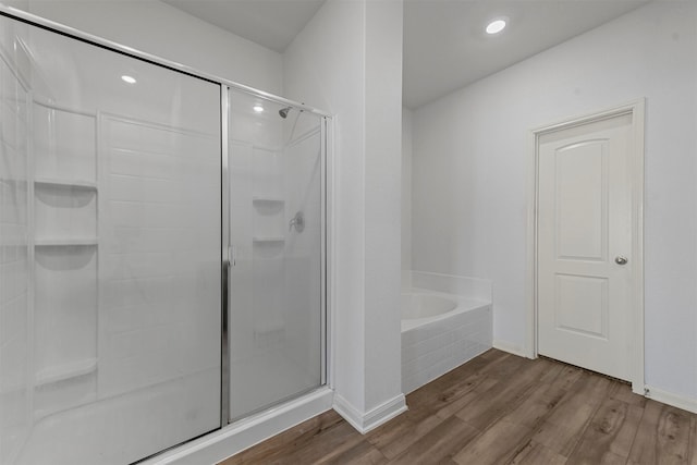 bathroom with hardwood / wood-style floors and shower with separate bathtub