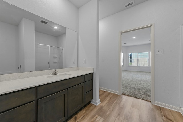 bathroom featuring vanity, hardwood / wood-style floors, and walk in shower