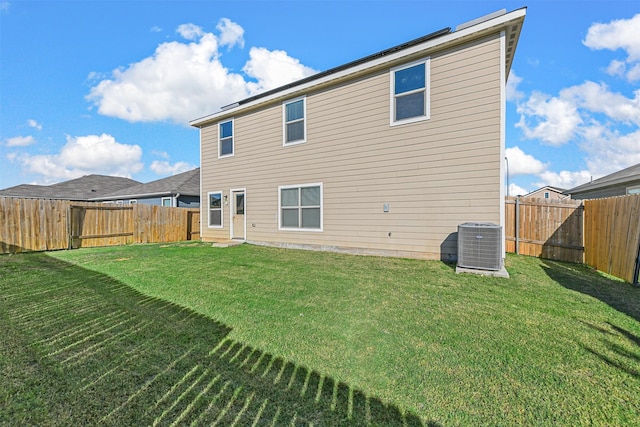 back of property featuring central AC and a lawn