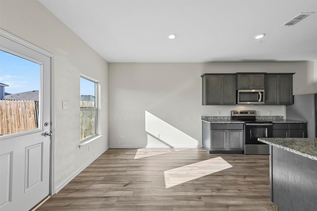 kitchen with stainless steel appliances, wood finished floors, visible vents, and recessed lighting