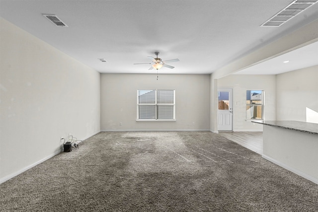 unfurnished living room with ceiling fan and carpet flooring