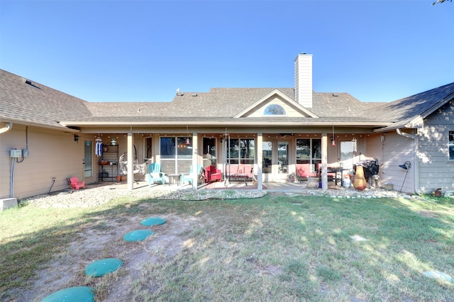 back of property featuring a patio and a lawn