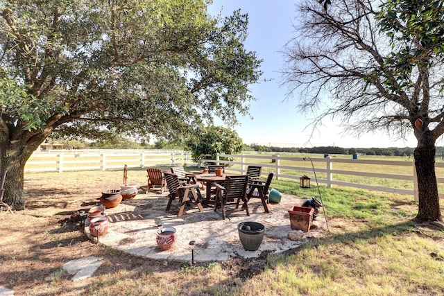 view of patio / terrace with a fire pit and a rural view