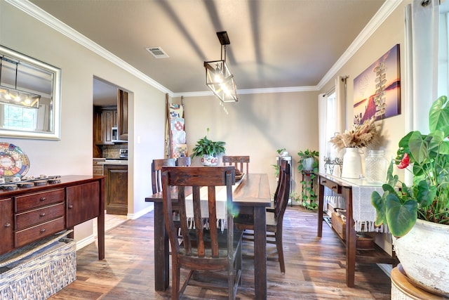 dining space featuring dark wood-type flooring and crown molding