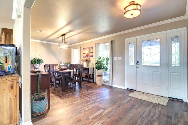 foyer with a textured ceiling, dark hardwood / wood-style floors, and ornamental molding