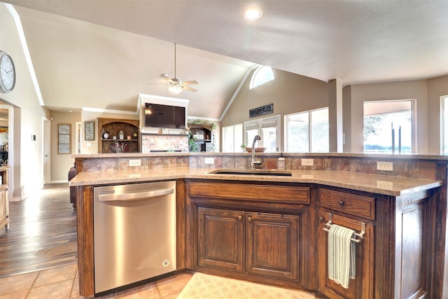 kitchen featuring a textured ceiling, lofted ceiling, sink, and stainless steel dishwasher