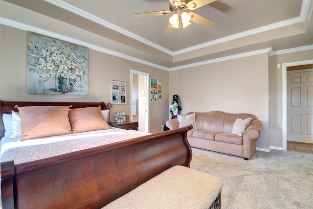 carpeted bedroom featuring ornamental molding, ceiling fan, and a tray ceiling